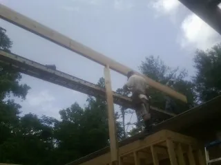 Carpenter setting a ridge beam over a new addition frame — Ice Dam Removal by Roofing Brothers in West Babylon