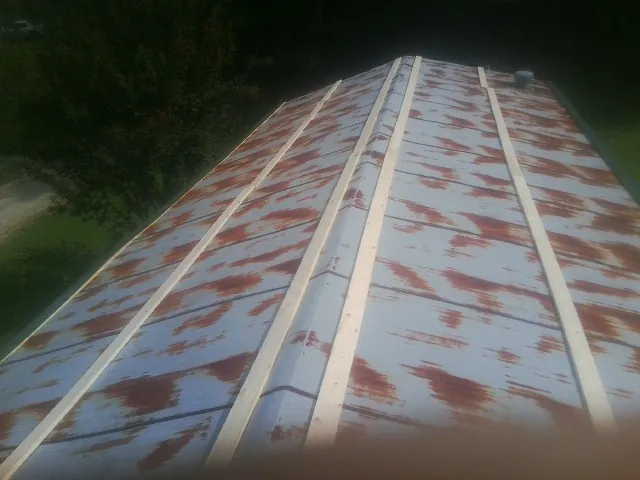 Rusted metal roof panels with new wood purlins before replacement — Storm Damage Roof Repair in West Babylon by Roofing Brothers