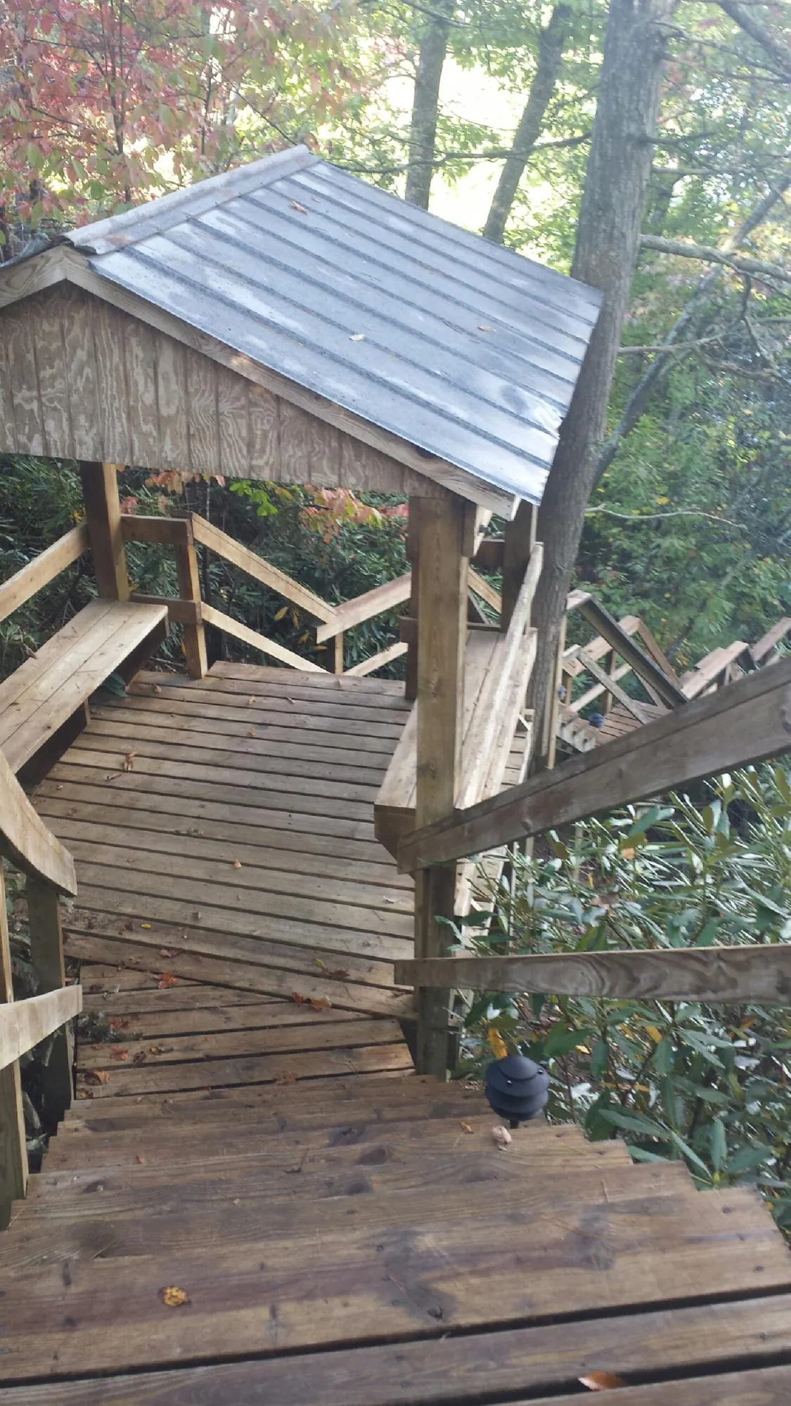 Metal roofed shelter over wooden steps on a wooded walkway — Skylight Repair & Installation work by our crew in West Babylon