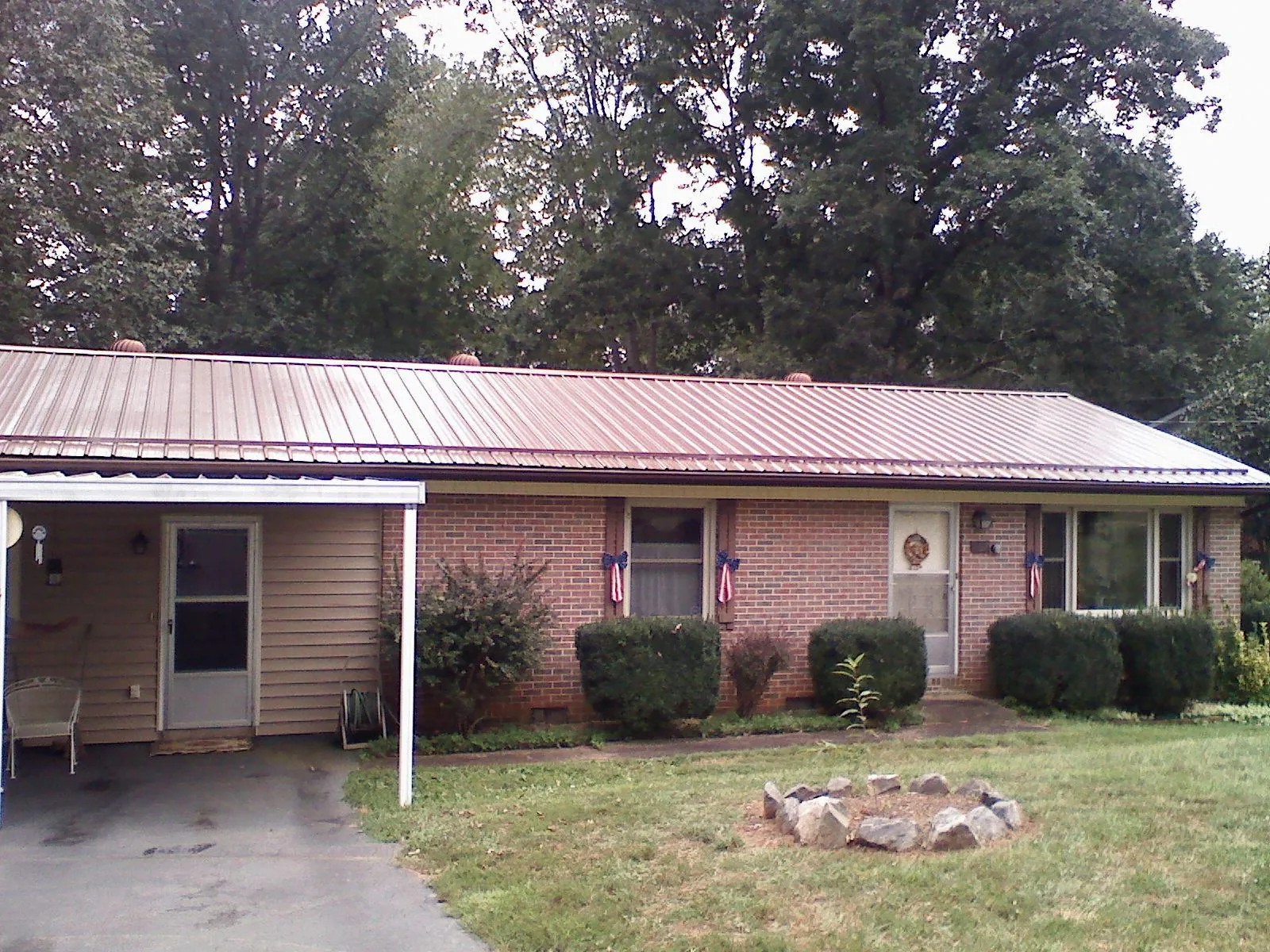 Bronze metal roof and carport on a brick ranch home — Roof Repair work by our crew in West Babylon